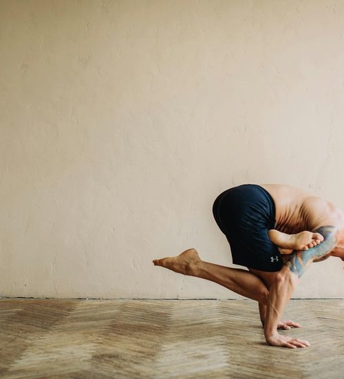 Man in a strong warrior yoga pose, showing balance and concentration.